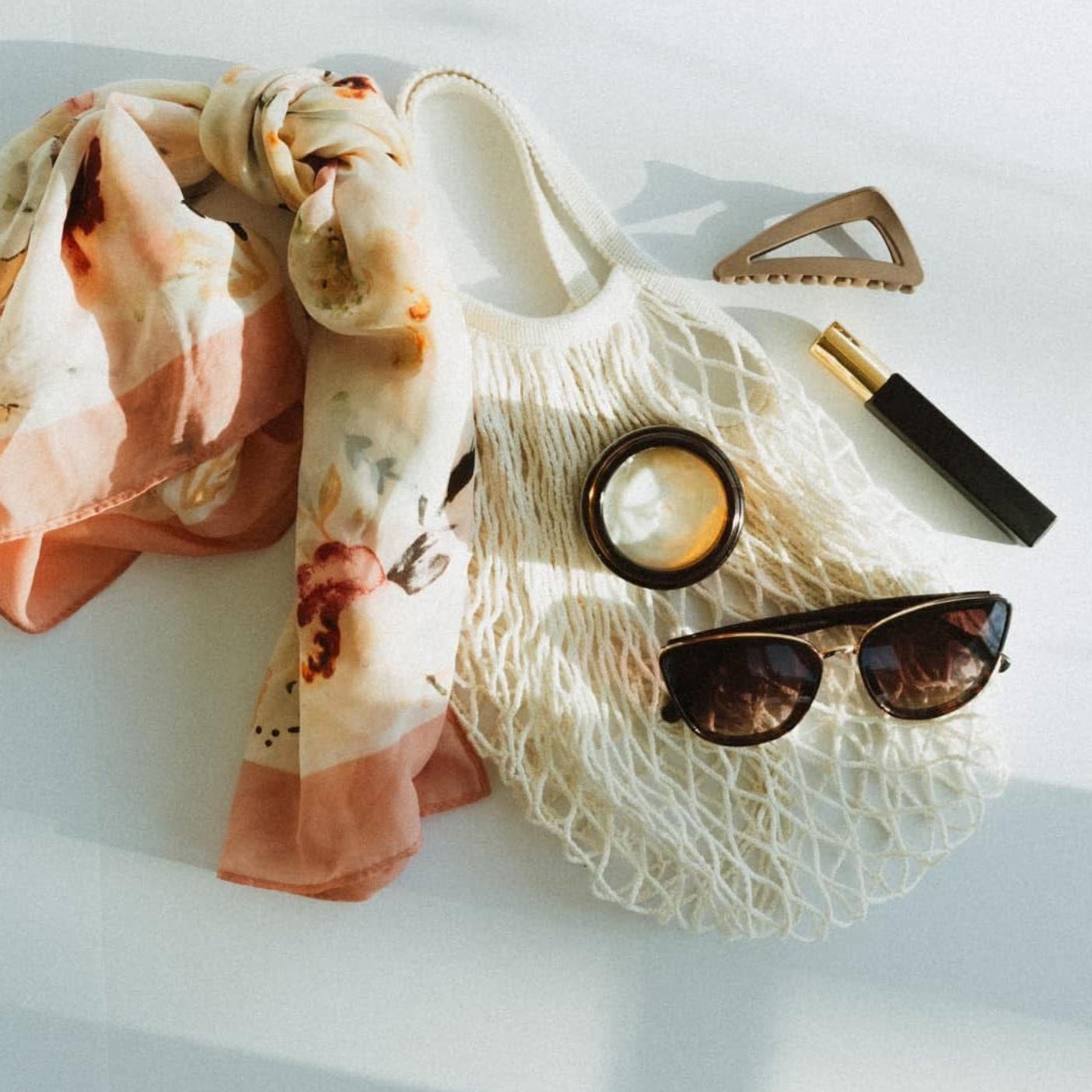 HydroTallow tallow balm packed in a beach tote with sunglasses and a scarf